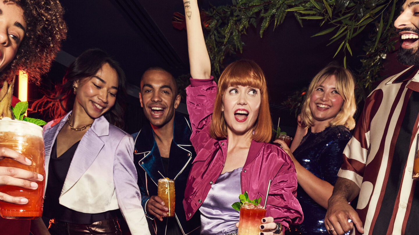 Group of young people enjoying a night out with Angostura rum cocktails